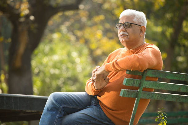 istock Thoughtful senior man sitting at park 1383917766