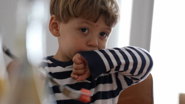 istock Candid child eating fruit snack at home 1383918948