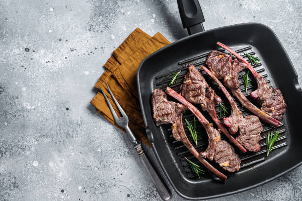 istock Fried on a grill skillet lamb cutlet steak, mutton rib chop. Gray background. Top view. Copy space 1383919019