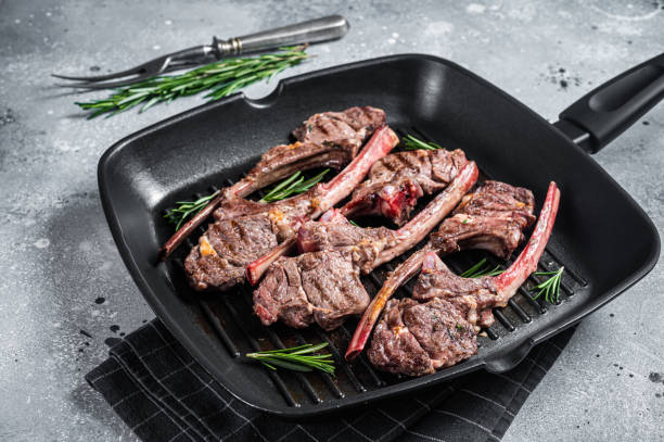 istock Fried on a grill skillet lamb cutlet steak, mutton rib chop. Gray background. Top view 1383919039