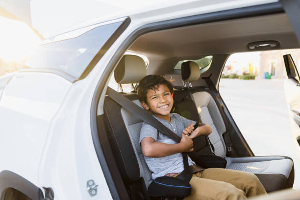 istock Elementary age boy cheerfully waits for parents to load car 1383919526