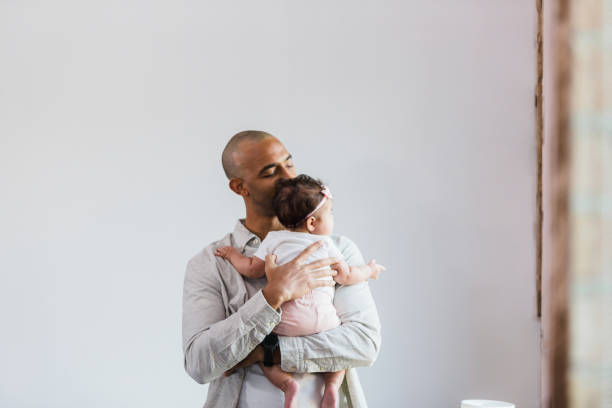 istock Single dad closes eyes and tenderly kisses baby's head 1383919546