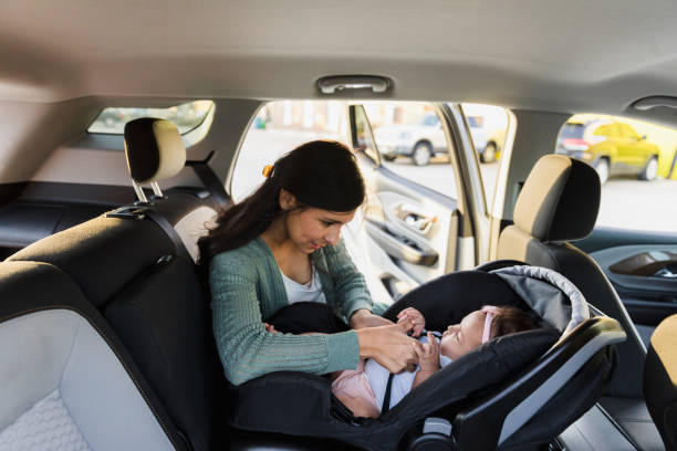 istock Mom interacts with baby while buckling her into safety seat 1383919596