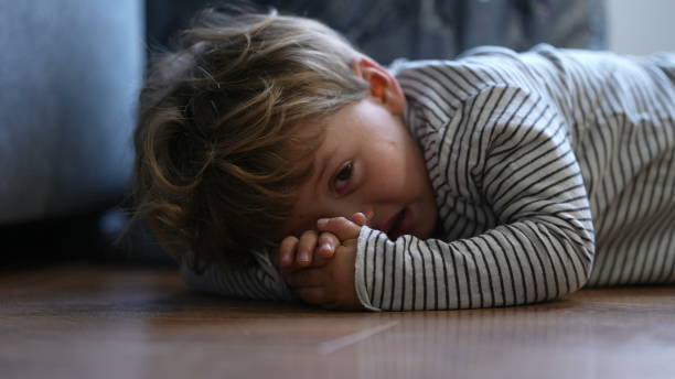 Child crying on floor having tantrum little boy cries stock photo