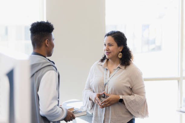 istock Female librarian patiently listens to unrecognizable male student 1383920773