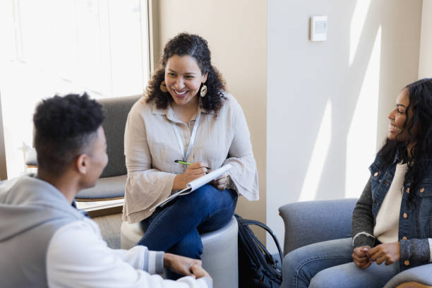 istock Female counselor and two teens smile while discussing college applications 1383920797