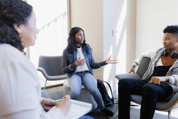 istock Sister gestures toward brother while sharing in therapy 1383921325