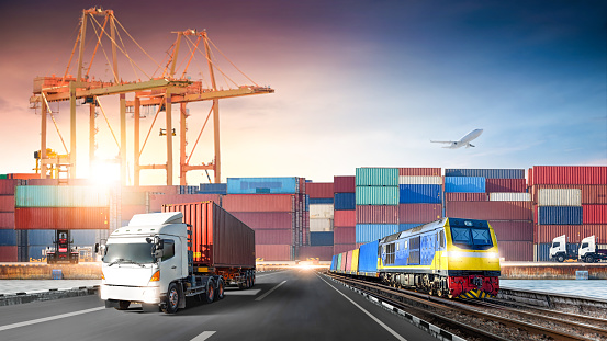 Global business logistics import export of red container truck on highway and freight train at port cargo shipping dock yard, Cargo airplane, Transportation industry concept, Depth blur effect