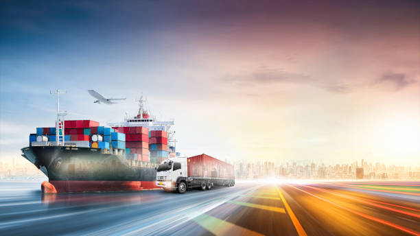 Logistics import export of containers cargo freight ship, truck transport with red container on highway at port cargo shipping dock yard background, copy space, plane, transportation industry concept stock photo