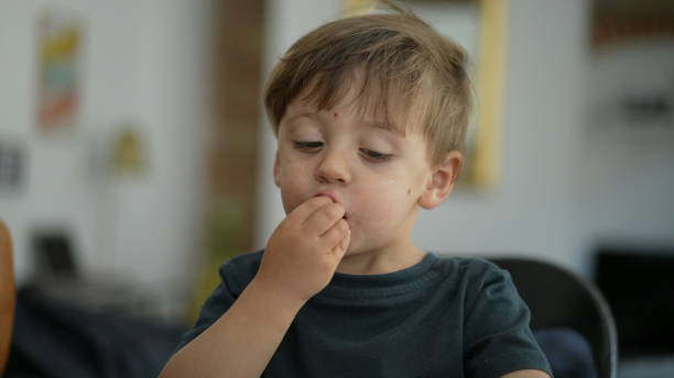 istock Happy child hitting table with hands eating fruit berry 1383934151