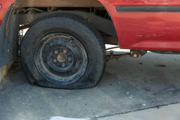 istock Destroyed blown out tire with exploded, shredded and damaged tire on a modern automobile. damaged truck rubber after tire explosion at high speed. Damaged flat tires: old car. 1383936920
