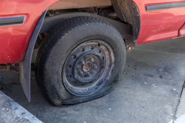 istock Destroyed blown out tire with exploded, shredded and damaged tire on a modern automobile. damaged truck rubber after tire explosion at high speed. Damaged flat tires: old car. 1383936923