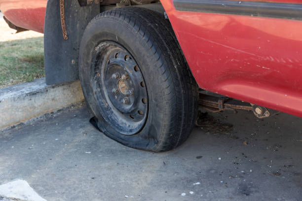 istock Destroyed blown out tire with exploded, shredded and damaged tire on a modern automobile. damaged truck rubber after tire explosion at high speed. Damaged flat tires: old car. 1383936950