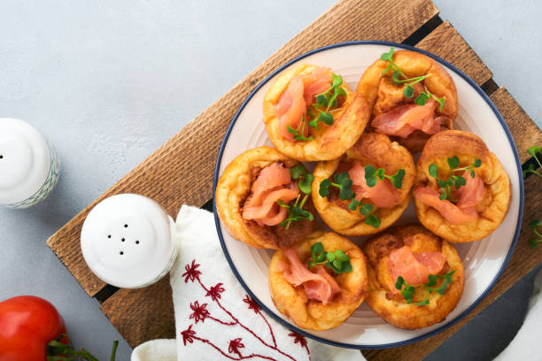 istock Yorkshire pudding. Traditional English Yorkshire pudding with salmon and radish microgreens side dish on white plate and light grey background table. Top view. 1383947540