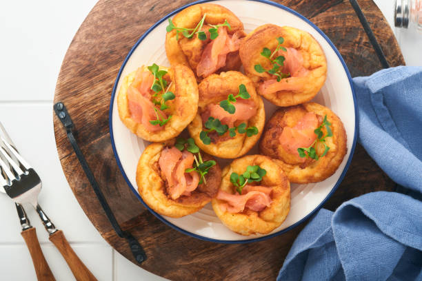 istock Yorkshire pudding. Traditional English Yorkshire pudding with salmon and radish microgreens side dish on white plate and light grey background table. Top view. 1383947878