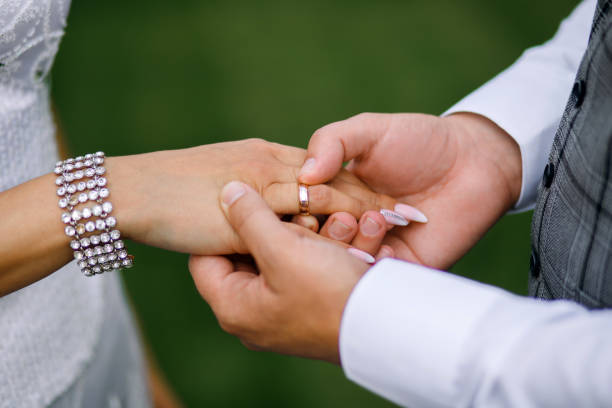 istock the groom puts a wedding ring on the bride hand, a beautiful wedding ceremony with fresh flowers, a beautiful girl and a courageous guy 1383947923