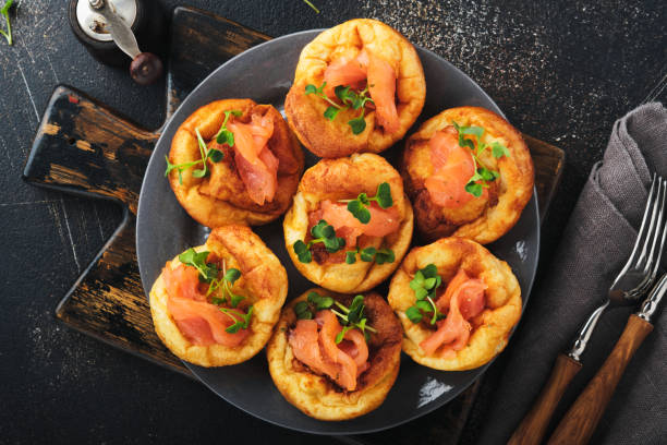 istock Yorkshire pudding. Traditional English Yorkshire pudding with salmon and radish microgreens side dish on dark grey plate and dark background table. Top view. 1383948037