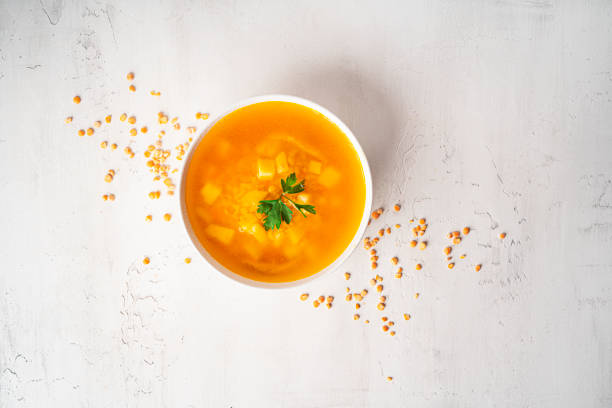 sopa de guisantes sobre un fondo claro. sopa de guisantes en un tazón blanco. un plato de sopa. perejil, mezcla de pimienta, salsa, pan - yellow split pea soup fotografías e imágenes de stock