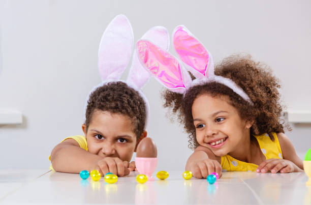 istock Black girl and a boy kids smile broadly play with Easter eggs 1383952546
