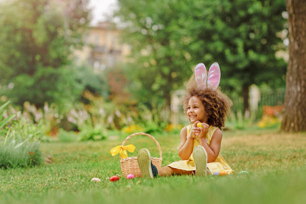 부활절 달걀을 모으는 토끼 귀를 휘두를 때리는 작은 흑인 소녀 - easter easter egg child chocolate 뉴스 사진 이미지