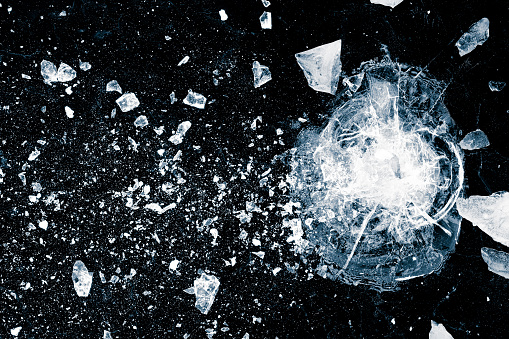 Cracked ice surface. Ice, crushed on black background. Pieces of crushed ice spread away.