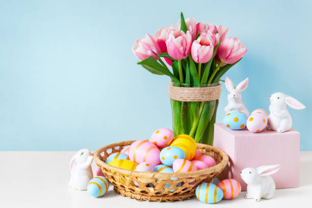 istock ink tulips, Easter bunnies with colorful eggs in basket and blue background. 1383953239