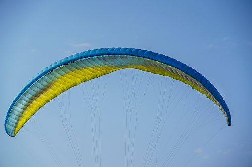 multicolored paraglider in flight, bottom view