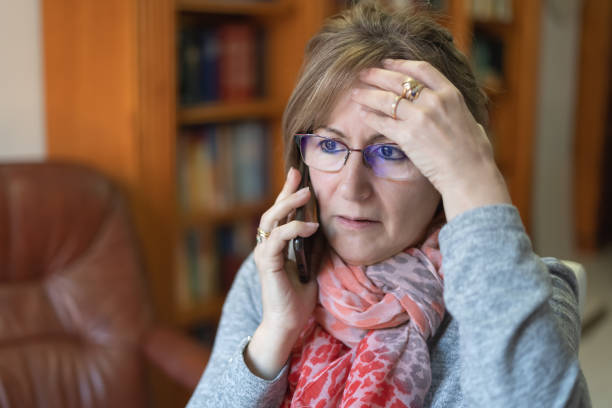 mujer blanca hablando por teléfono y recibiendo malas noticias con cara de preocupación. - women telephone senior adult on the phone fotografías e imágenes de stock