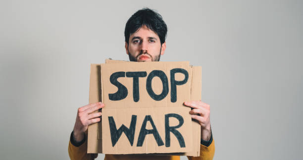 istock ukrainian guy holding a stop war placard in his hand 1383959875