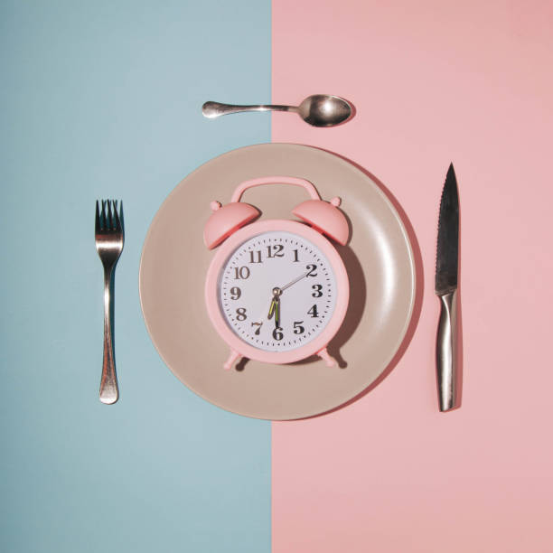istock A pink clock on a plate, a blue-pink background, shows the time for breakfast 1383960144