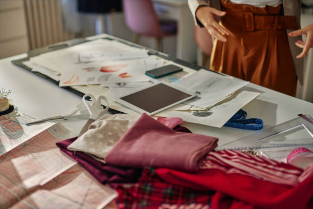 istock Close up of table and unrecognized woman in designer studio 1383961288