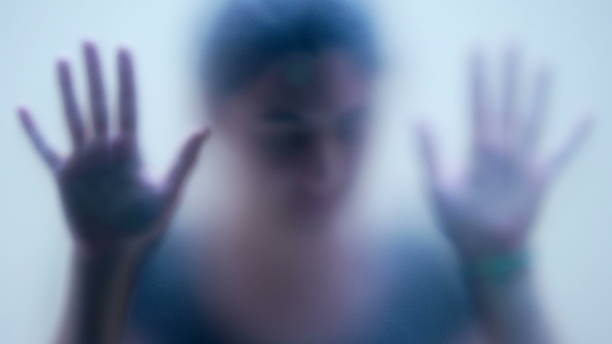 Woman behind matte glass blurry hand and body depression concept stock photo