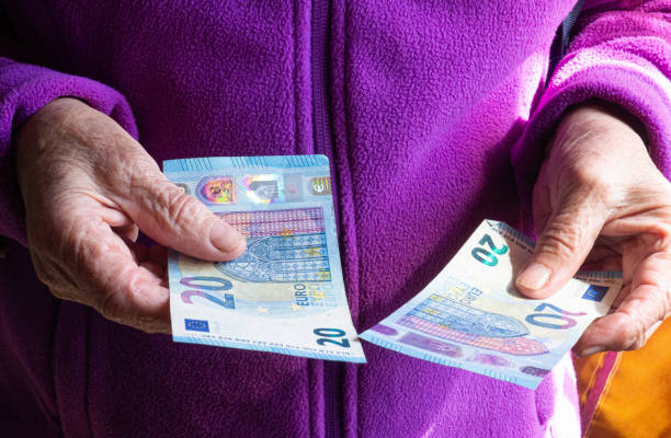 Woman's hands are holding a few euro coins. Pension, poverty, social problems and the theme of old age. Saving. Woman's hands are holding a few euro coins. Pension, poverty, social problems and the theme of old age. Saving. top gold ira stock pictures, royalty-free photos & images