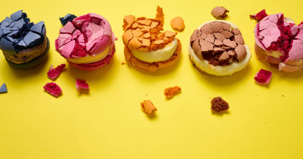 istock broken round macarons with crumbs on a yellow background, delicious dessert, top view 1383965381