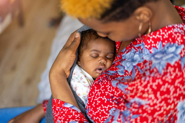 istock Mother cuddling sleeping baby at home 1383965474