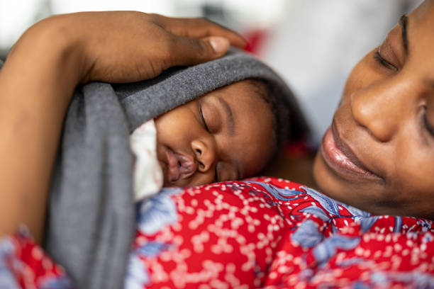 istock Mother cuddling sleeping baby at home 1383965594