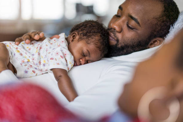 padre sosteniendo a su bebé en brazos en casa - 2 5 meses fotografías e imágenes de stock