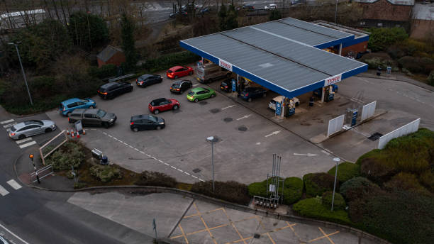 Wigan, UK: March 10, 2022: Aerial View. Queuing cars waiting to buy fuel at a Tesco petrol filling station as British drivers panic buy fuel stock photo