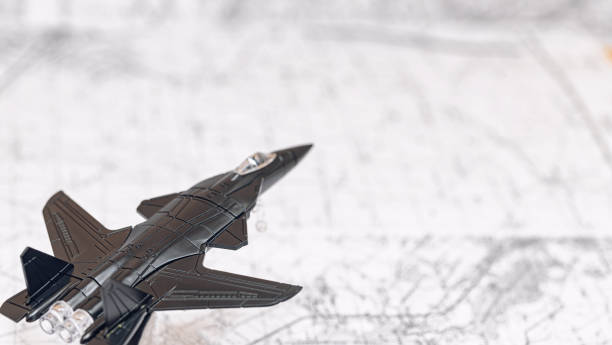 istock A black toy combat aircraft flies over a map 1383967792