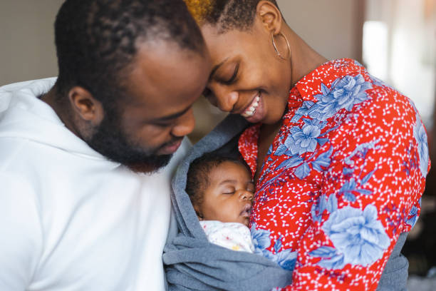 padres jóvenes con su bebé en casa - newborn fotografías e imágenes de stock