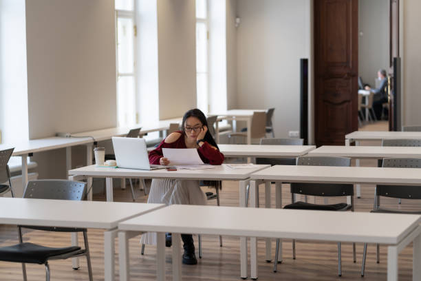 istock Asian student girl feeling tired and unmotivated while studying in university library 1383968031