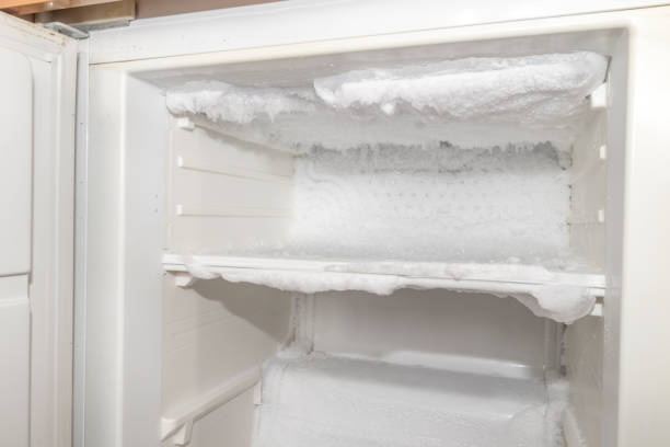 Ice inside a fridge. Defrosting freezer. stock photo