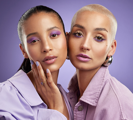 Shot of two beautiful young women posing in purple