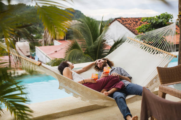 istock Young couple lying down in a hammock 1383974860