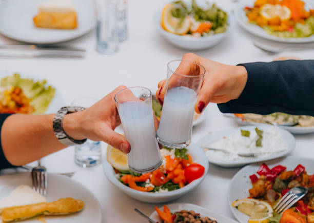 전통 저녁 식사에서 터키 라키와 함께 재미와 토스트를 하는 커플의 가까이보기 - greek cuisine greek culture food table 뉴스 사진 이미지