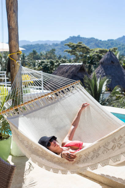 istock Young woman lying down in a hammock 1383977290