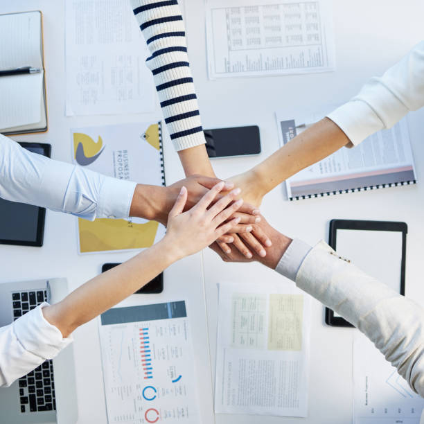 istock Shot of a group of unrecognizable businesspeople stacking their hands at work 1383977362