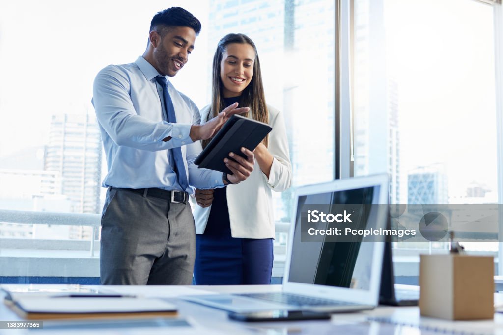 Shot of two businesspeople discussing something on a digital tablet This is some impressive stuff Business Person Stock Photo