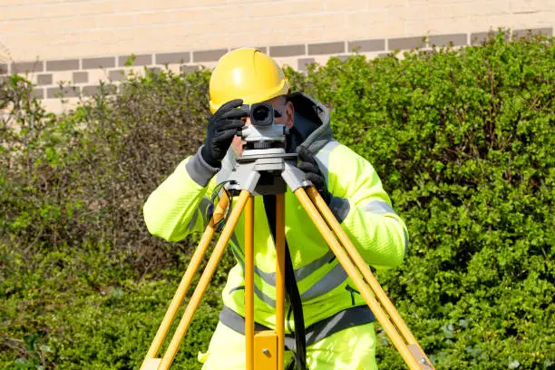 Photo of Site engineer checking levels of the road using autolevel