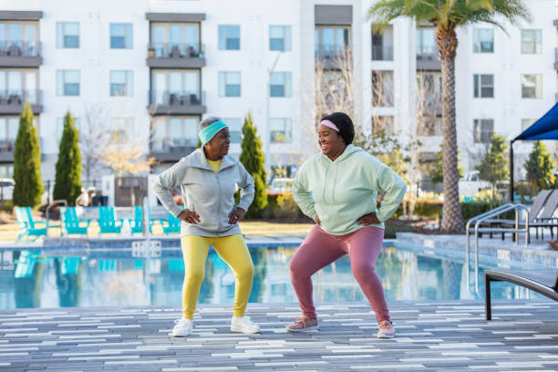 Two African-American women working out on pool deck